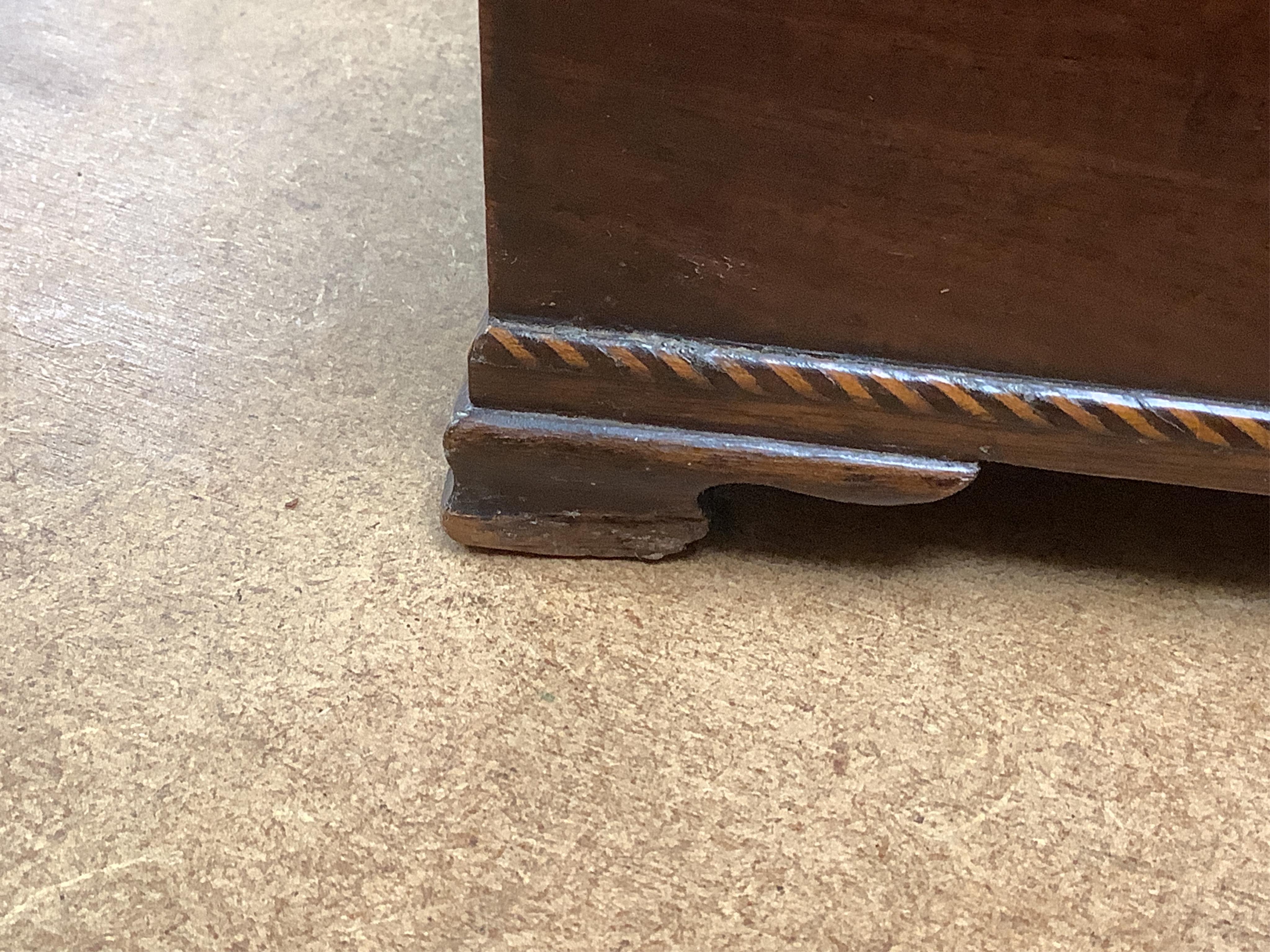 A George III mahogany tea caddy, containing tinned metal canisters, 25cm wide